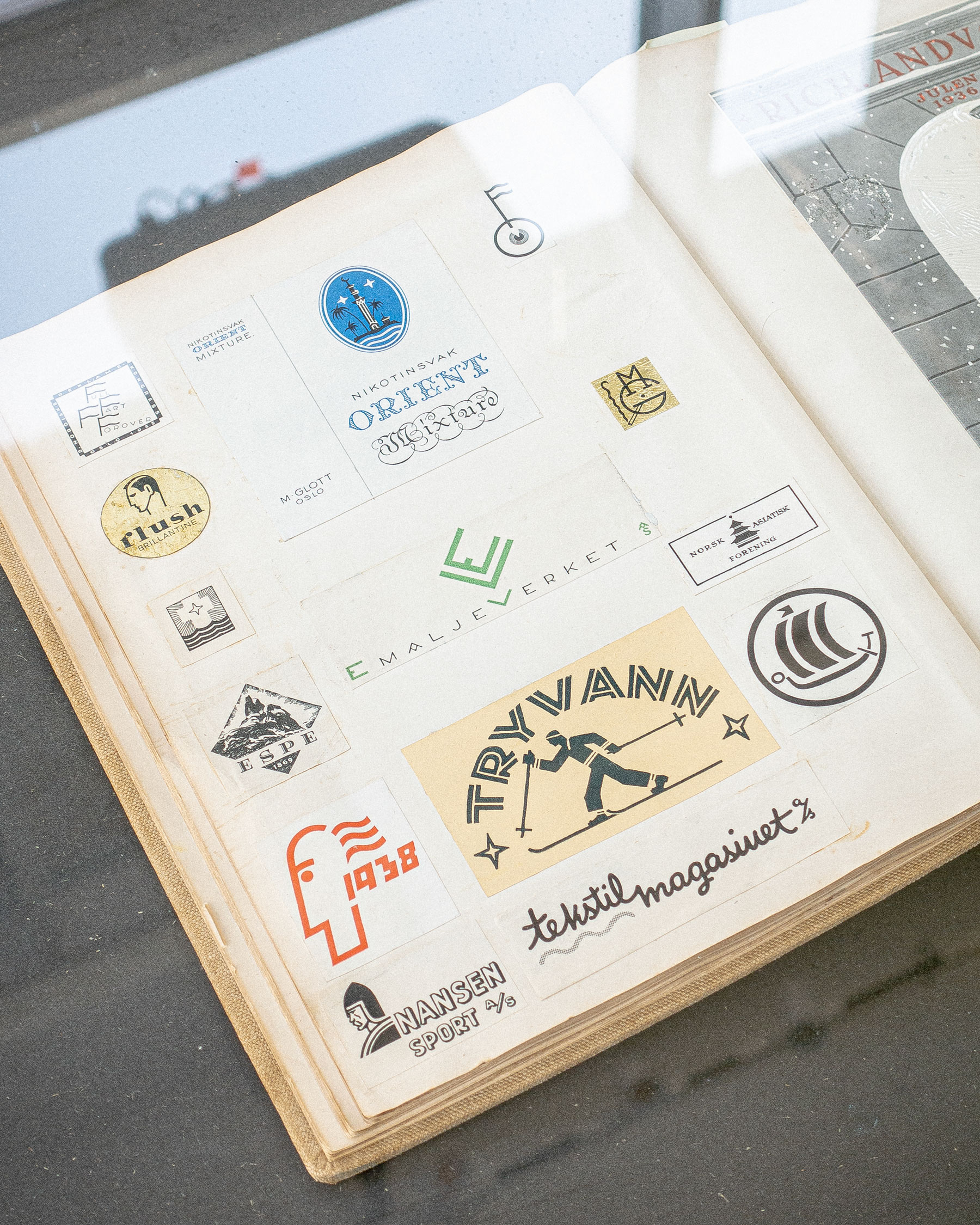 Scrapbook spread with logos and marks in the exhibition Ingen veit kven Trygve er